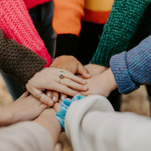 Multiple hands meeting on top of one another in a circle