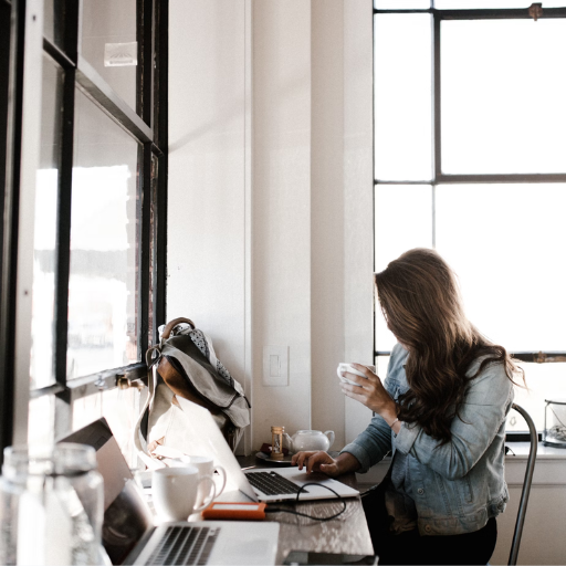 Woman working in a local cafe drinking from mug