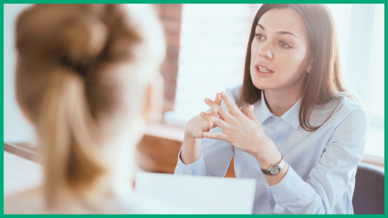 A focus photo of one person talking as they discuss with the other blurred in frame